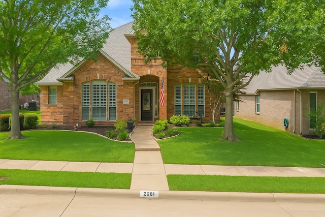 2081 Ashbourne Dr, Rockwall, TX 75087 - view of front facade with brick siding, a front lawn, and a shingled roof