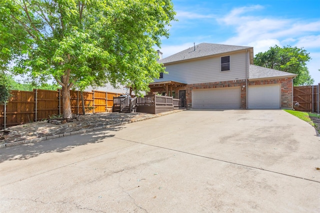 2081 Ashbourne Dr, Rockwall, TX 75087 - view of front of home featuring concrete driveway, an attached garage, a deck, and roof with shingles