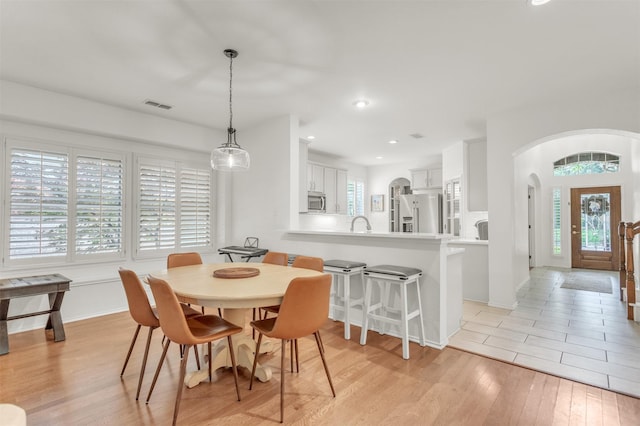 2081 Ashbourne Dr, Rockwall, TX 75087 - dining area with arched walkways, light wood-style flooring, recessed lighting, and baseboards