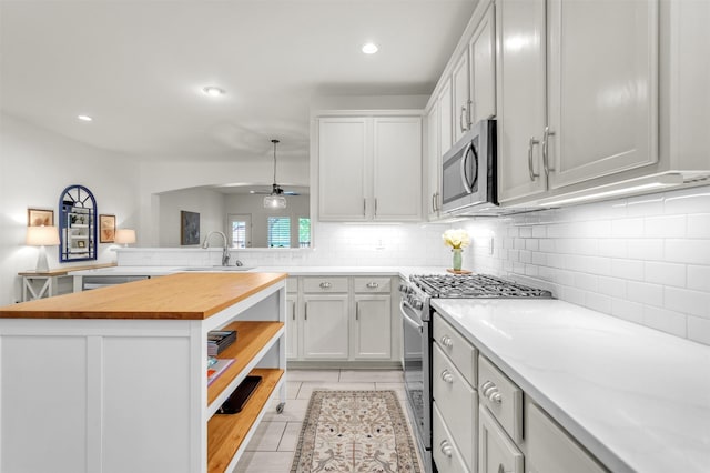 2081 Ashbourne Dr, Rockwall, TX 75087 - kitchen with appliances with stainless steel finishes, butcher block counters, a sink, decorative backsplash, and ceiling fan