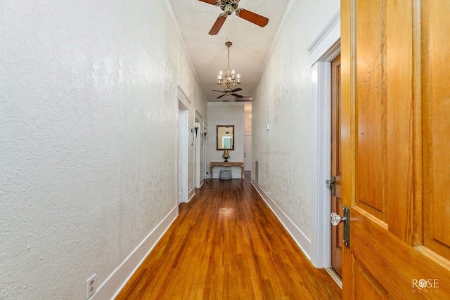 112 5th Ave, Coleman, TX 76834 - corridor featuring wood finished floors, a chandelier, a textured wall, and baseboards