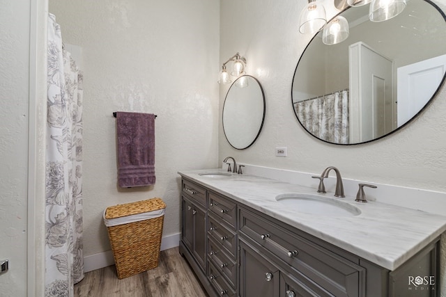 112 5th Ave, Coleman, TX 76834 - bathroom with double vanity, wood finished floors, and baseboards