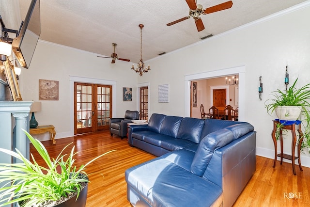 112 5th Ave, Coleman, TX 76834 - living room featuring ceiling fan, a chandelier, french doors, light wood-style flooring, and ornamental molding