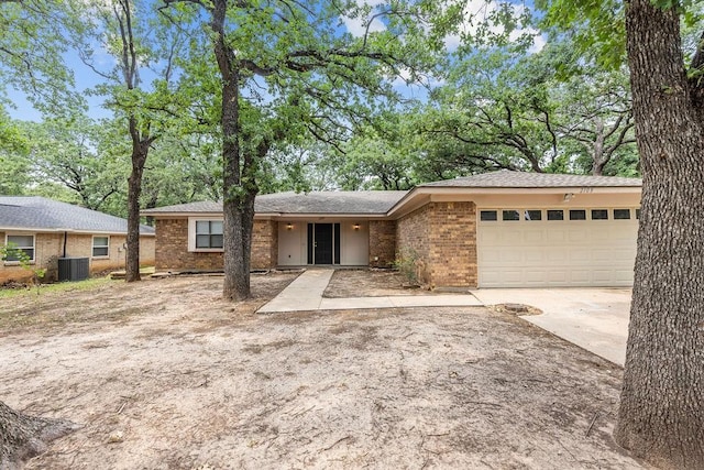 2109 Dartmouth Dr, Arlington, TX 76015 - view of front of home with brick siding, a garage, driveway, and central AC unit