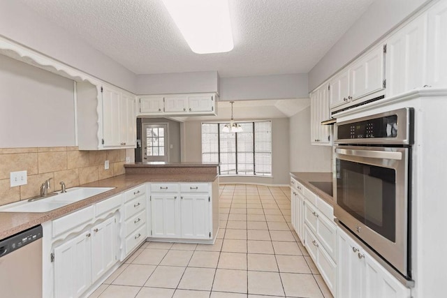 2109 Dartmouth Dr, Arlington, TX 76015 - kitchen with a sink, stainless steel appliances, a textured ceiling, and white cabinetry