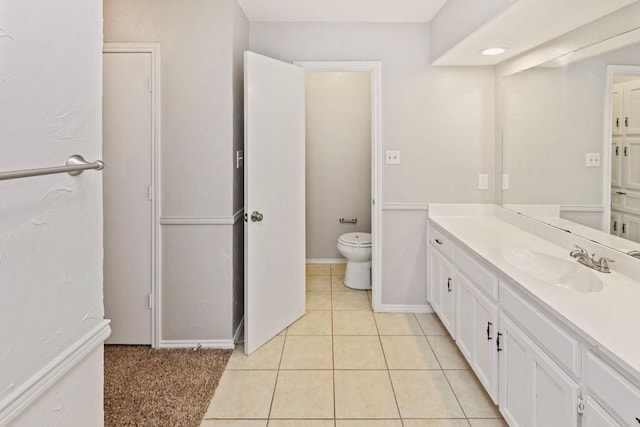 2109 Dartmouth Dr, Arlington, TX 76015 - bathroom featuring vanity, toilet, tile patterned flooring, and baseboards