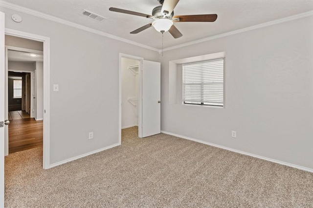 2109 Dartmouth Dr, Arlington, TX 76015 - unfurnished bedroom featuring carpet floors, a walk in closet, ornamental molding, baseboards, and a closet