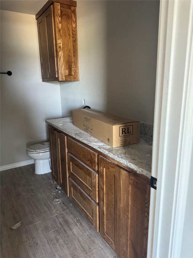 1009 Brown Ct, Poolville, TX 76487 - bathroom featuring toilet, wood finished floors, and baseboards