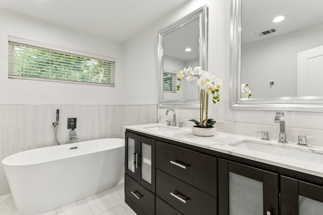 9132 Choctaw Trl, Flower Mound, TX 75022 - full bathroom with double vanity, a freestanding bath, tile walls, tile patterned flooring, and a wainscoted wall