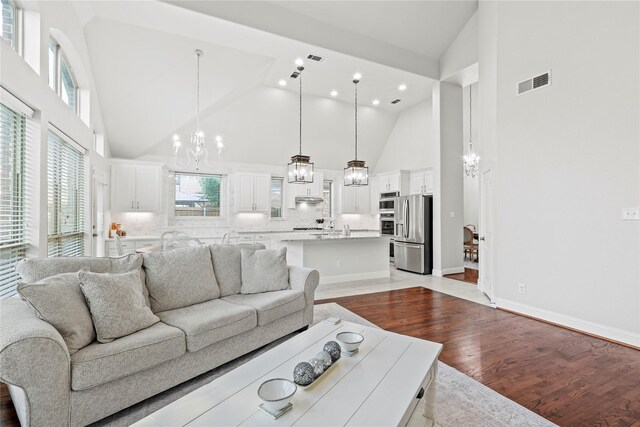 7224 Bucanero, Grand Prairie, TX 75054 - living area with high vaulted ceiling, a chandelier, wood finished floors, baseboards, and recessed lighting