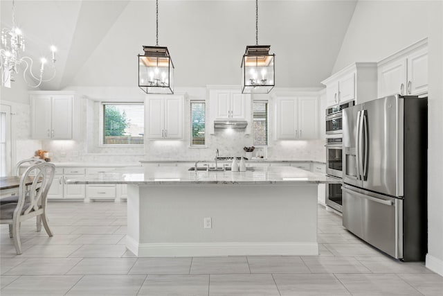 7224 Bucanero, Grand Prairie, TX 75054 - kitchen featuring appliances with stainless steel finishes, a chandelier, high vaulted ceiling, tasteful backsplash, and white cabinetry