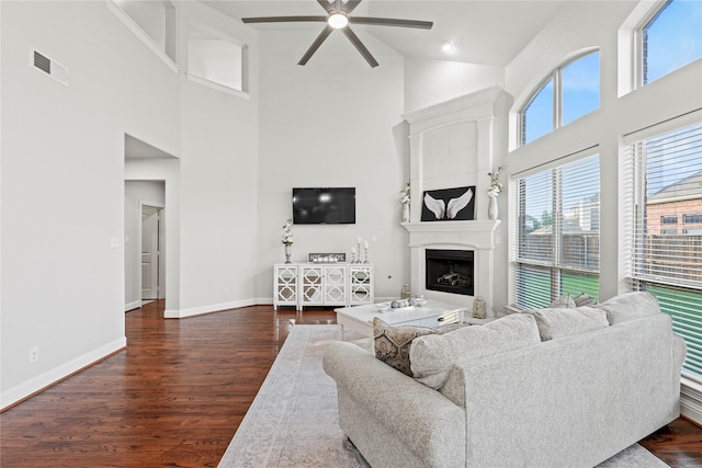 7224 Bucanero, Grand Prairie, TX 75054 - living room featuring a ceiling fan, a high ceiling, baseboards, dark wood finished floors, and a fireplace