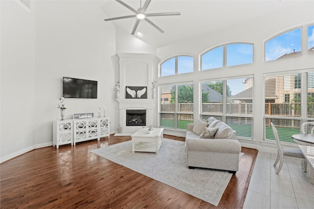 7224 Bucanero, Grand Prairie, TX 75054 - living area with high vaulted ceiling, a ceiling fan, wood finished floors, a fireplace with raised hearth, and baseboards