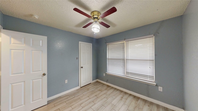 928 Thistle Ridge Ln, Arlington, TX 76017 - empty room with ceiling fan, a textured ceiling, light wood-style flooring, baseboards, and a smoke detector