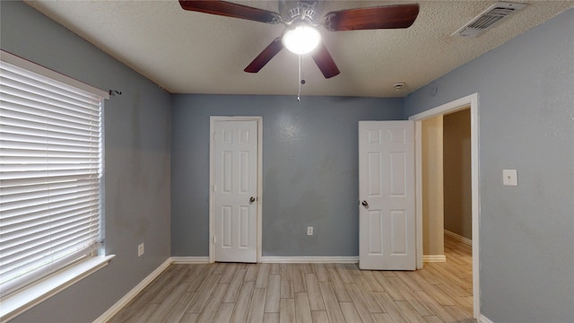928 Thistle Ridge Ln, Arlington, TX 76017 - unfurnished bedroom featuring light wood-style floors, baseboards, a textured ceiling, and a ceiling fan