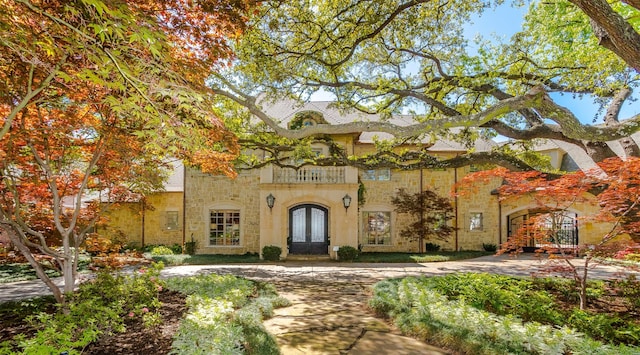 6406 Glendora Ave, Dallas, TX 75230 - mediterranean / spanish-style house featuring stone siding, french doors, and a balcony
