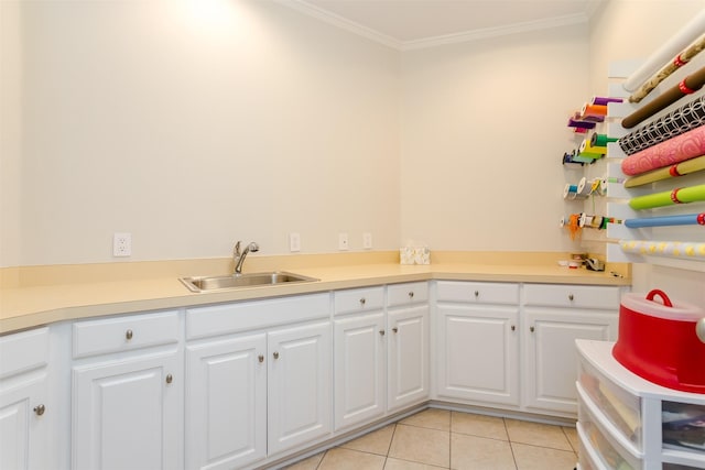 6406 Glendora Ave, Dallas, TX 75230 - kitchen with a sink, ornamental molding, light tile patterned floors, white cabinetry, and light countertops