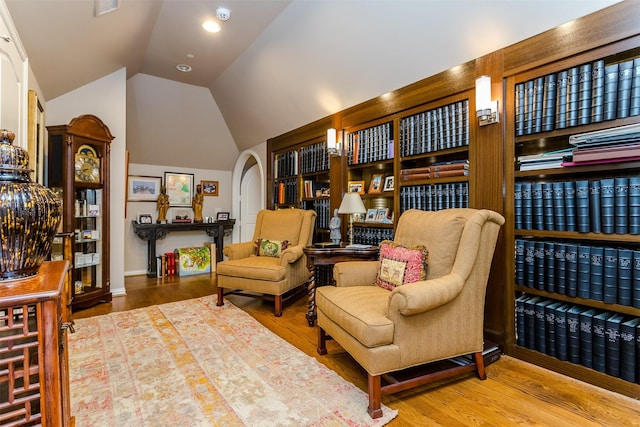 6406 Glendora Ave, Dallas, TX 75230 - living area featuring lofted ceiling, wood finished floors, arched walkways, and baseboards