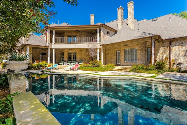 6406 Glendora Ave, Dallas, TX 75230 - rear view of house featuring a ceiling fan, a balcony, a patio area, an outdoor pool, and brick siding