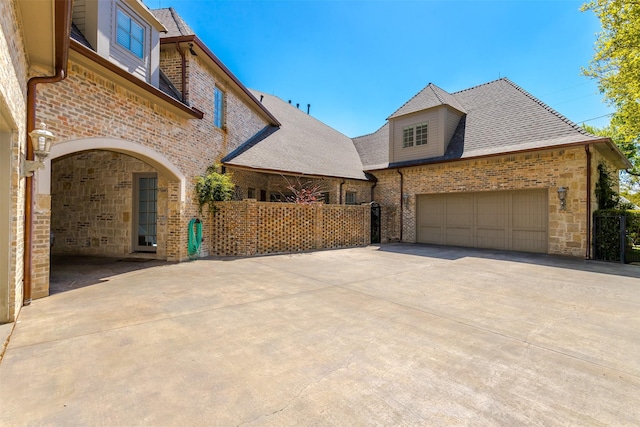 6406 Glendora Ave, Dallas, TX 75230 - view of side of home featuring driveway, brick siding, an attached garage, stone siding, and roof with shingles