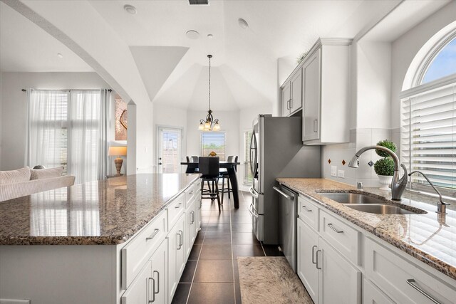 2604 Grand Colonial St, Grand Prairie, TX 75054 - kitchen with a sink, appliances with stainless steel finishes, a kitchen island, stone counters, and hanging light fixtures