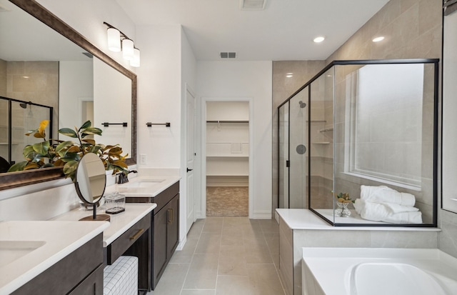 4267 Arlington Ave, Mckinney, TX 75071 - full bathroom with a stall shower, two vanities, a bath, a spacious closet, and tile patterned flooring