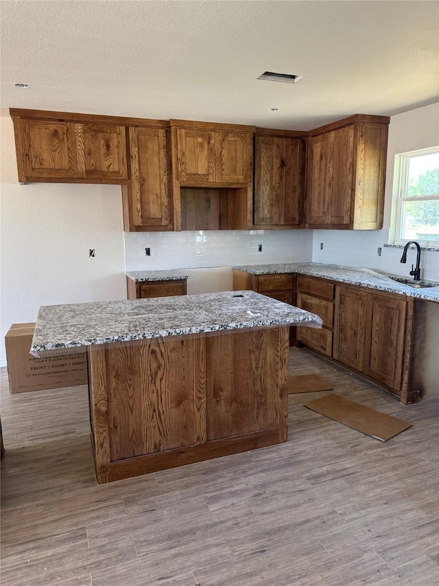 1013 Brown Ct, Poolville, TX 76487 - kitchen featuring a sink, backsplash, and light wood finished floors