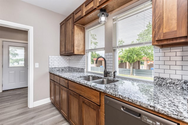 322 E Division St, Muenster, TX 76252 - kitchen with dishwasher, a sink, light stone counters, light wood finished floors, and tasteful backsplash