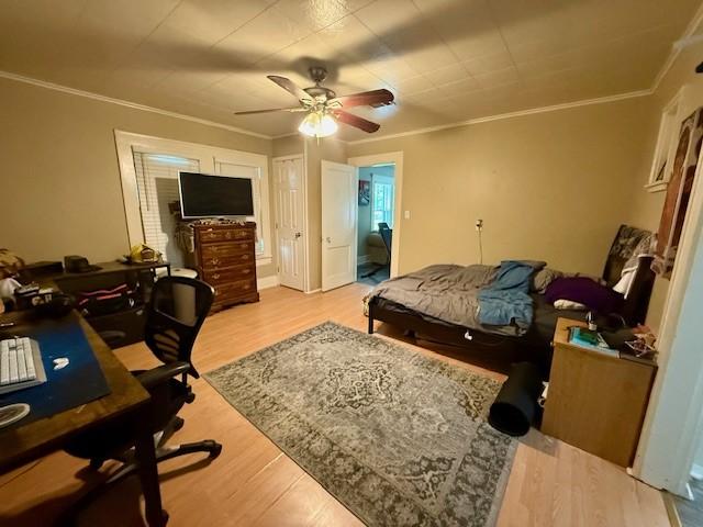 322 E Division St, Muenster, TX 76252 - bedroom with ornamental molding, light wood-style floors, a desk, and a ceiling fan