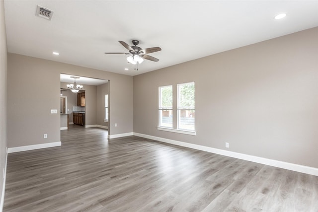 322 E Division St, Muenster, TX 76252 - empty room featuring a chandelier, a ceiling fan, recessed lighting, wood finished floors, and baseboards