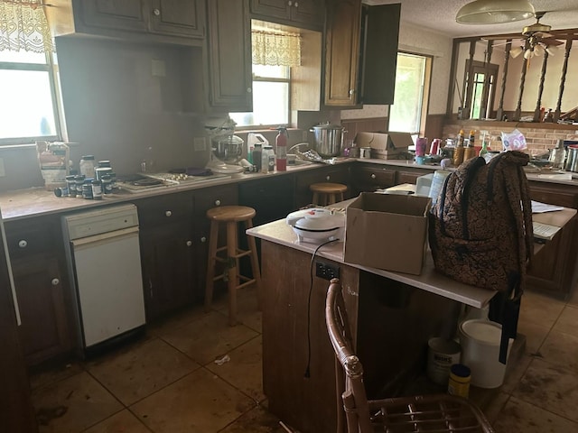 3182 E US Highway 84, Palestine, TX 75801 - kitchen featuring tile patterned flooring, light countertops, a ceiling fan, white stovetop, and a textured ceiling