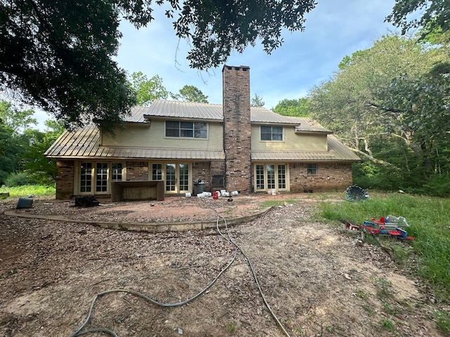 3182 E US Highway 84, Palestine, TX 75801 - back of house with french doors, a patio, a chimney, metal roof, and brick siding