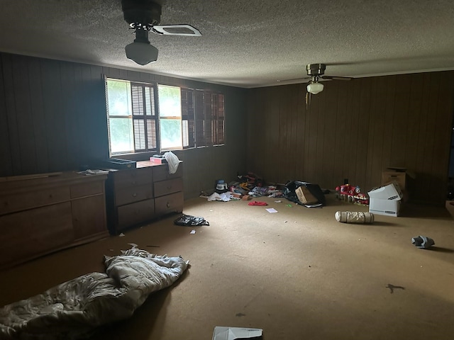 3182 E US Highway 84, Palestine, TX 75801 - unfurnished bedroom featuring a textured ceiling, ceiling fan, and wood walls