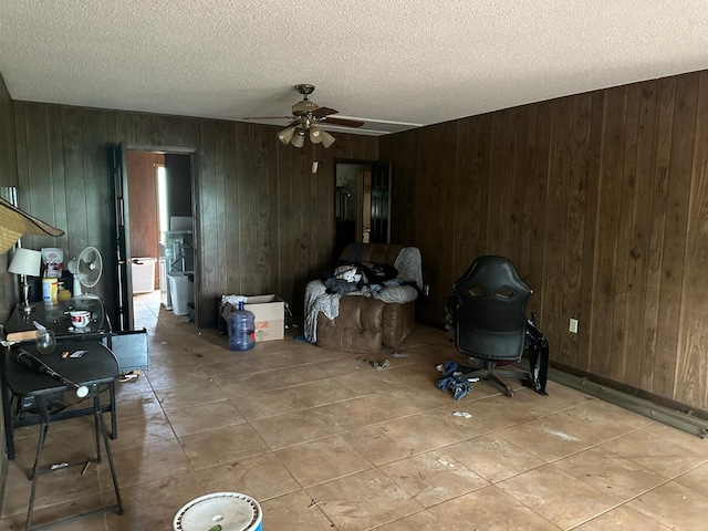 3182 E US Highway 84, Palestine, TX 75801 - unfurnished living room with ceiling fan, a textured ceiling, wooden walls, and light tile patterned floors