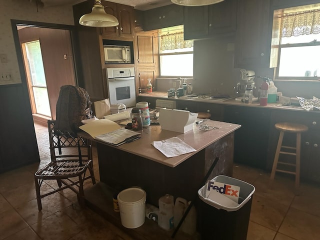 3182 E US Highway 84, Palestine, TX 75801 - kitchen with white appliances, tile patterned flooring, light countertops, and a center island