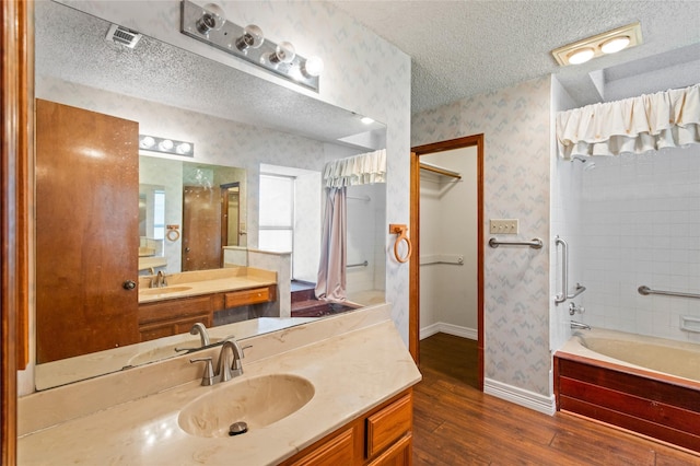 2025 Sancerre Ln, Carrollton, TX 75007 - full bath with a textured ceiling, wood finished floors, wallpapered walls, baseboards, and  shower combination