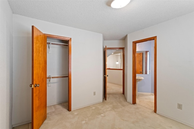 2025 Sancerre Ln, Carrollton, TX 75007 - unfurnished bedroom with light carpet, a closet, a textured ceiling, ensuite bath, and baseboards