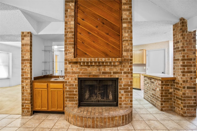2025 Sancerre Ln, Carrollton, TX 75007 - unfurnished living room with light tile patterned floors, a textured ceiling, a fireplace, and a sink