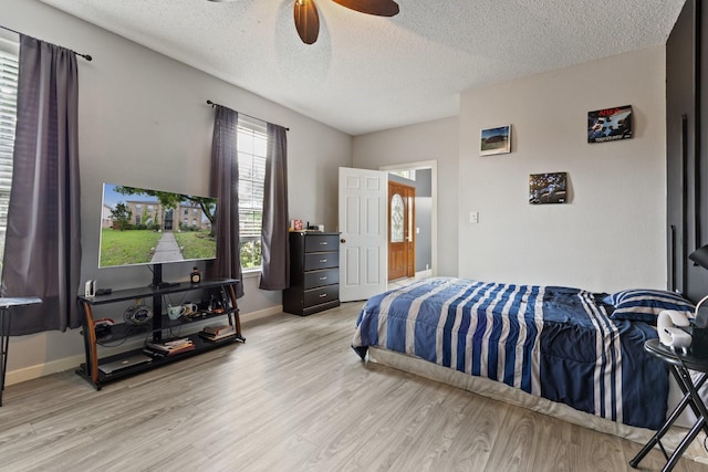 1317 Woodthorpe Dr, Mesquite, TX 75181 - bedroom featuring light wood-type flooring, a textured ceiling, a ceiling fan, and baseboards