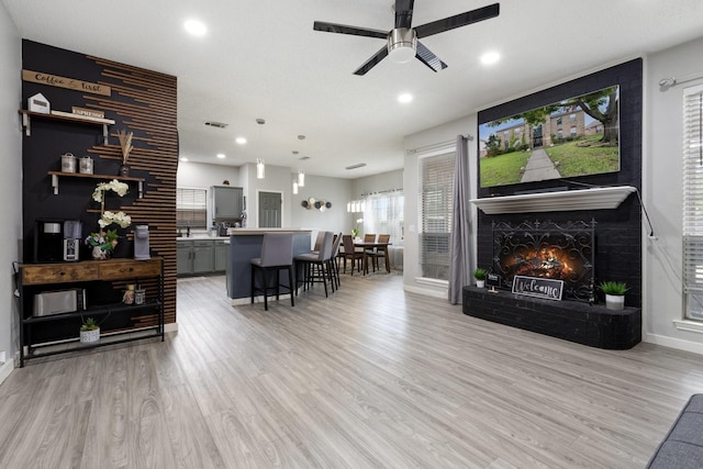 1317 Woodthorpe Dr, Mesquite, TX 75181 - living area featuring a ceiling fan, a brick fireplace, recessed lighting, light wood-style flooring, and baseboards