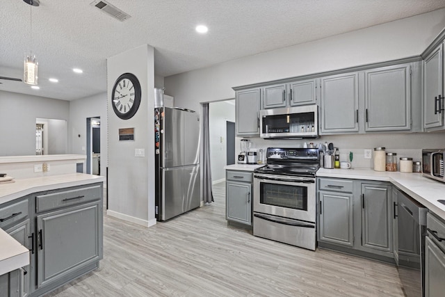 1317 Woodthorpe Dr, Mesquite, TX 75181 - kitchen with stainless steel appliances, gray cabinets, a textured ceiling, light countertops, and light wood-style floors