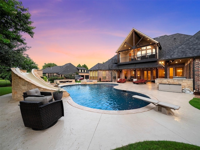 2901 Lakeview Dr, Prosper, TX 75078 - pool at dusk with a patio, a water slide, a diving board, and a pool with connected hot tub