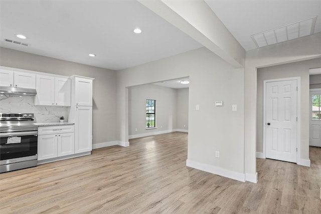 104 W 2nd St, Waxahachie, TX 75165 - kitchen with electric stove, under cabinet range hood, plenty of natural light, white cabinetry, and recessed lighting