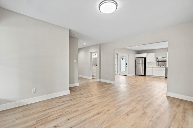 104 W 2nd St, Waxahachie, TX 75165 - unfurnished living room with light wood-style flooring, baseboards, and recessed lighting