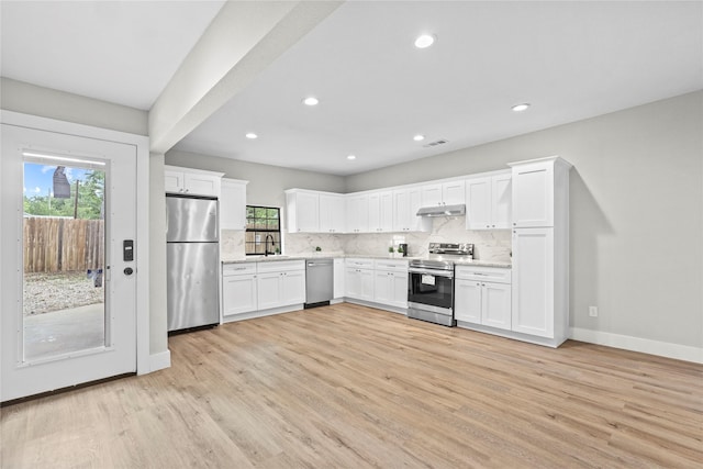 104 W 2nd St, Waxahachie, TX 75165 - kitchen featuring appliances with stainless steel finishes, backsplash, white cabinets, baseboards, and light wood finished floors