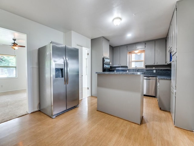 5512 Dennis Ave, Fort Worth, TX 76114 - kitchen featuring appliances with stainless steel finishes, gray cabinetry, a ceiling fan, dark countertops, and light wood-type flooring