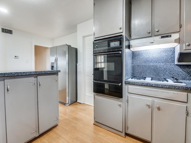 5512 Dennis Ave, Fort Worth, TX 76114 - kitchen featuring oven, stainless steel fridge, a warming drawer, under cabinet range hood, and white gas stovetop