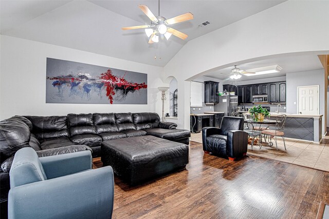 4621 Maple Hill Dr, Fort Worth, TX 76123 - living area featuring arched walkways, a ceiling fan, vaulted ceiling, and light wood finished floors