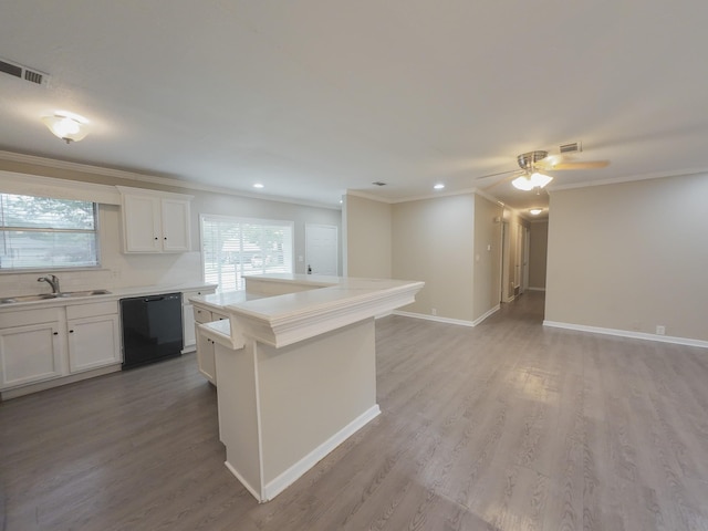 1418 Royal Dr, Kaufman, TX 75142 - kitchen with black dishwasher, a sink, ornamental molding, white cabinets, and light countertops