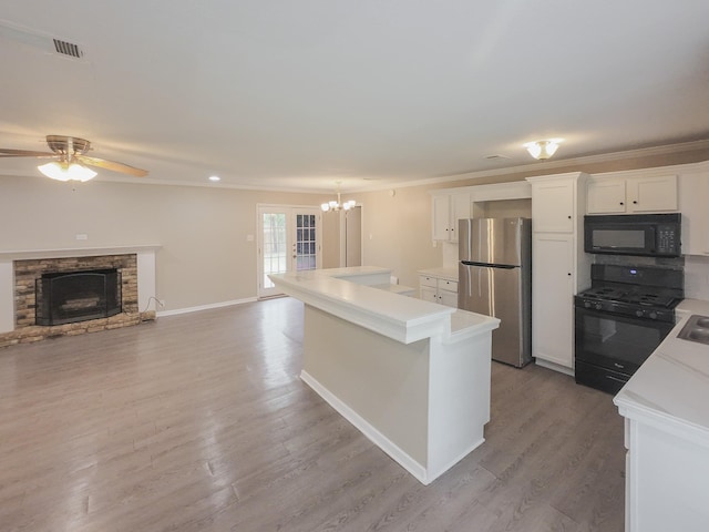 1418 Royal Dr, Kaufman, TX 75142 - kitchen featuring black appliances, light countertops, white cabinetry, a center island, and a chandelier